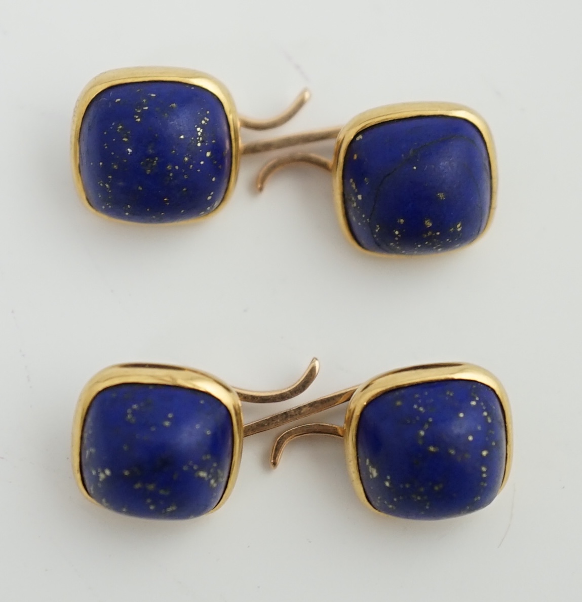 A pair of gold mounted cabochon lapis lazuli set cufflinks